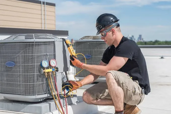 Technician checking a rooftop air conditioning unit during HVAC service
